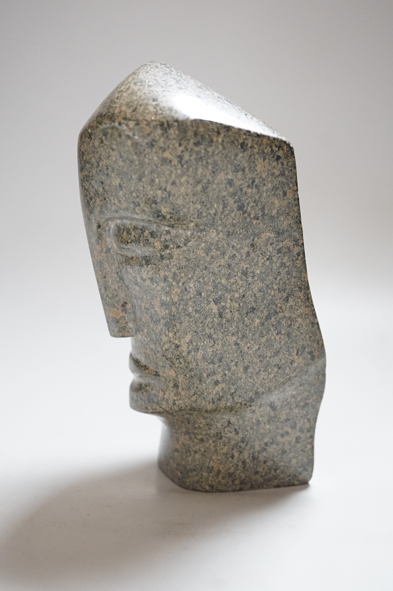 A carved stone head, 23cms high